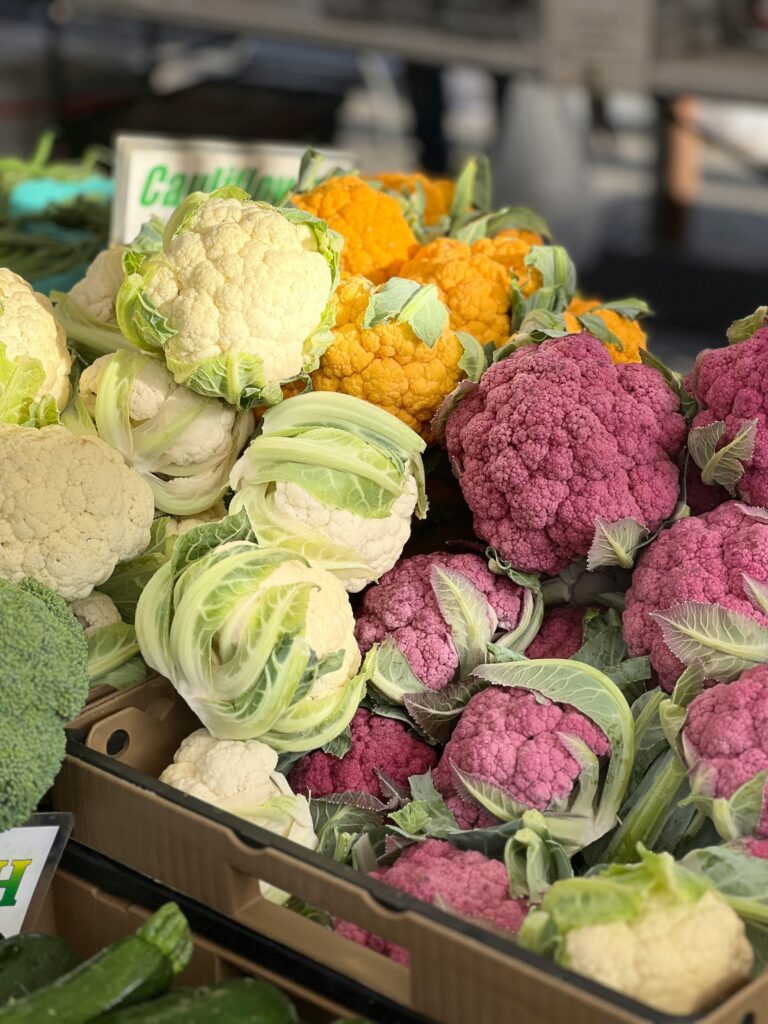 A vibrant assortment of cauliflower varieties on display at a local market.